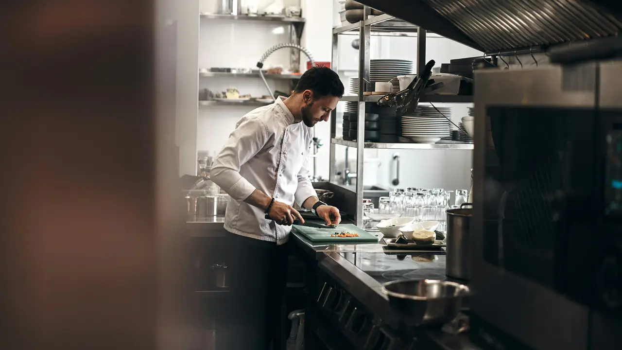 Cuisinier qui prépare un plat sur son plan de travail