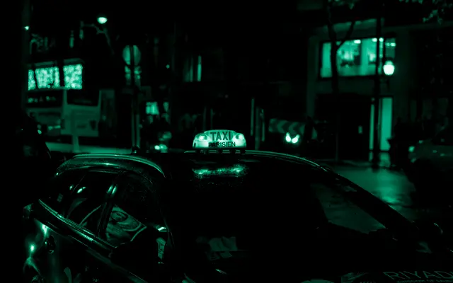 Taxi dans une rue de nuit, lumineux allumé